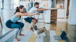 Man and woman perform squats at home