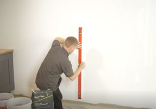 man measuring wall with tape