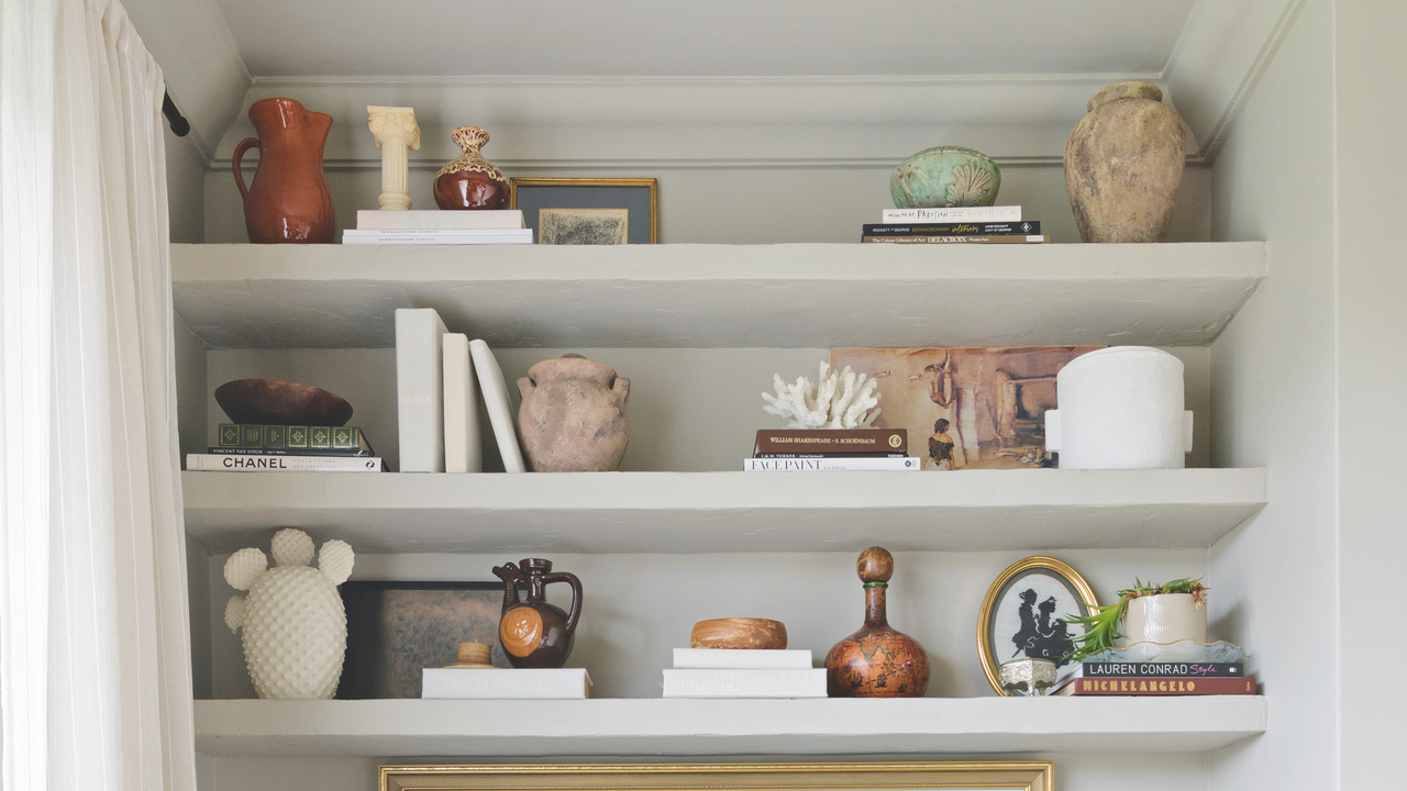 thre shelves each arranged with ornaments and books