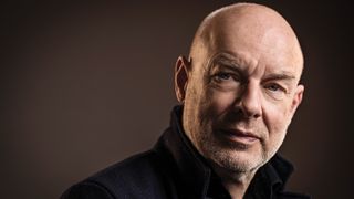 Brian Eno 2016 solo shot against a dark background