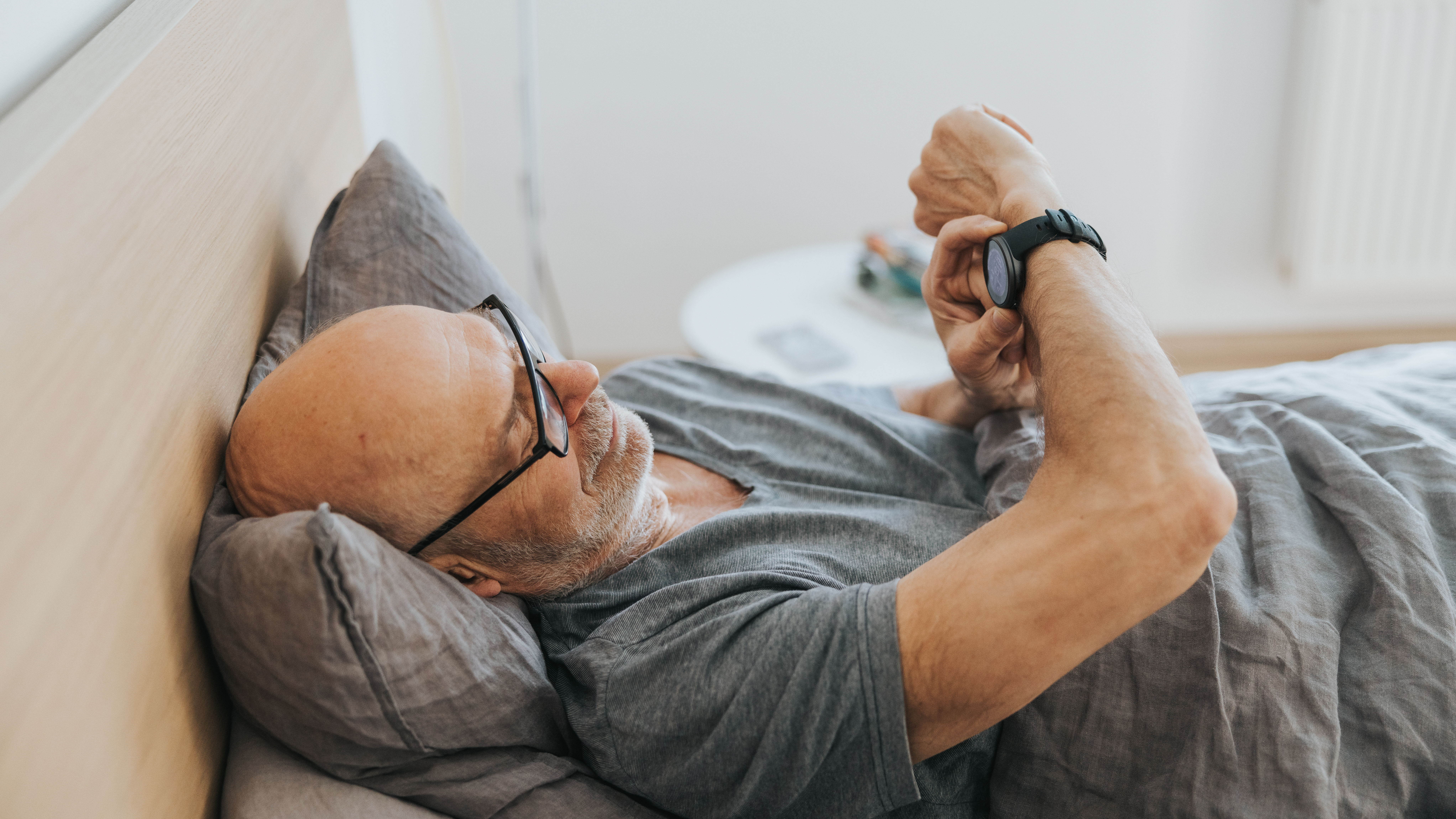 Man using fitness tracker in bed