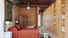 A stunning bedroom with wooden cupboards, a room divider hiding a bathtub, a marble stool, a red bed with an overhead hanging rug, and a pair of tiled side tables with table lamps