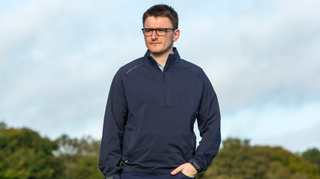 A golfer wears the Peter Millar Shield Rain Shell Jacket