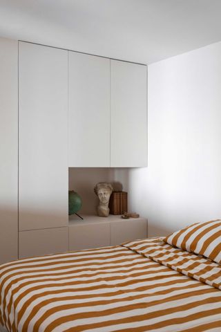 a bedroom with a nightstand built into the closet