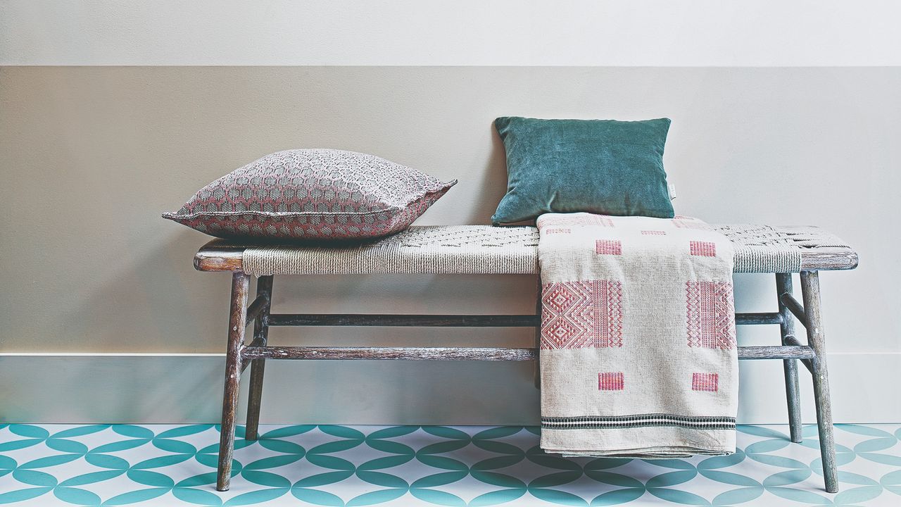 A hallway with a seating bench with cushions and blankets