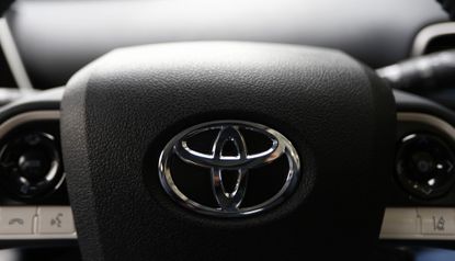 The Toyota Motor Corp. logo on a steering wheel