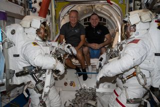 In this image, Expedition 63 flight engineers NASA astronaut Doug Hurley (middle left) and cosmonaut Ivan Vagner (middle right) helped to prepare NASA astronauts Bob Behnken and Chris Cassidy for a spacewalk on June 26, 2020. Cassidy and Behnken stepped out for a spacewalk in which they replaced aging nickel-hydrogen batteries on the space station with brand new lithium-ion batteries. The pair embarked on another battery swap spacewalk today (July 1.)