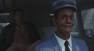 Screenshot from Total Recall showing Arnold Shwarzenegger sitting in a driverless car controlled by Johnny Cab.