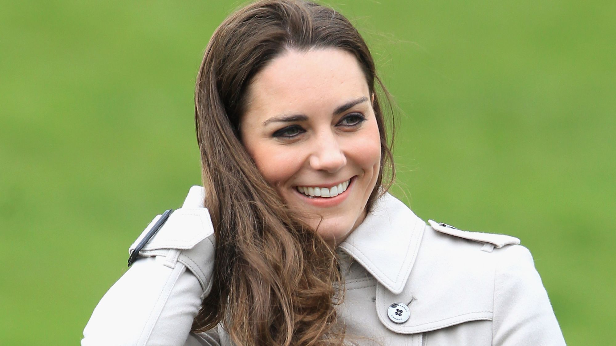 Kate Middleton smiles and touches her hair as she visits Greenmount Agricultural College on March 8, 2011 in Belfast