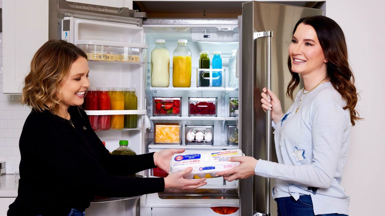 The Home Edit holding eggbox infront of fridge