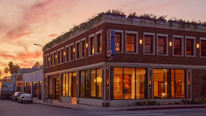 NeueHouse Venice Beach building exterior, lit from within at dusk