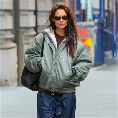 Katie Holmes outfit repeat in shearling bomber jacket, nylon pants, and adias sambas