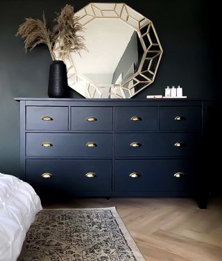 A big chest of drawers in dark blue with copper-toned handles