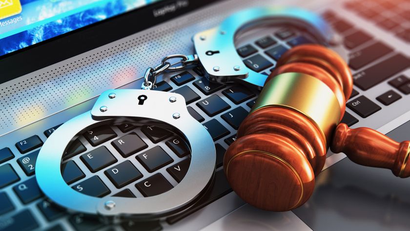 Handcuffs and gavel resting on the keyboard of a laptop PC.