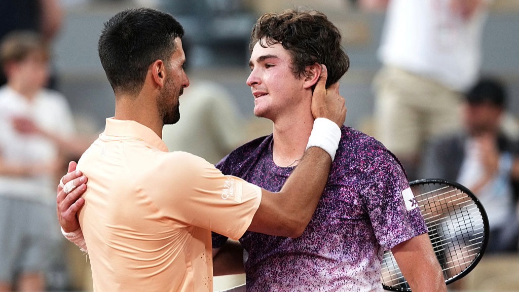 Novak Djokovic embraces Joao Fonseca after losing to the Brazilian teenager at the French Open 2026.