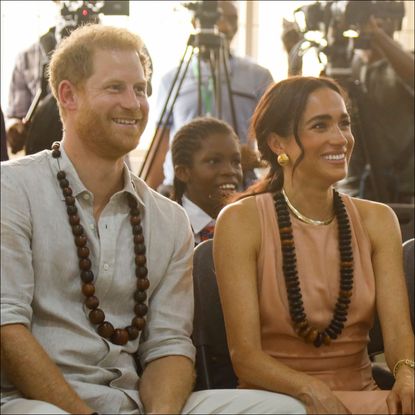 Prince Harry wears a shirt and Meghan Markle wears a pastel dress during a tour of Nigeria