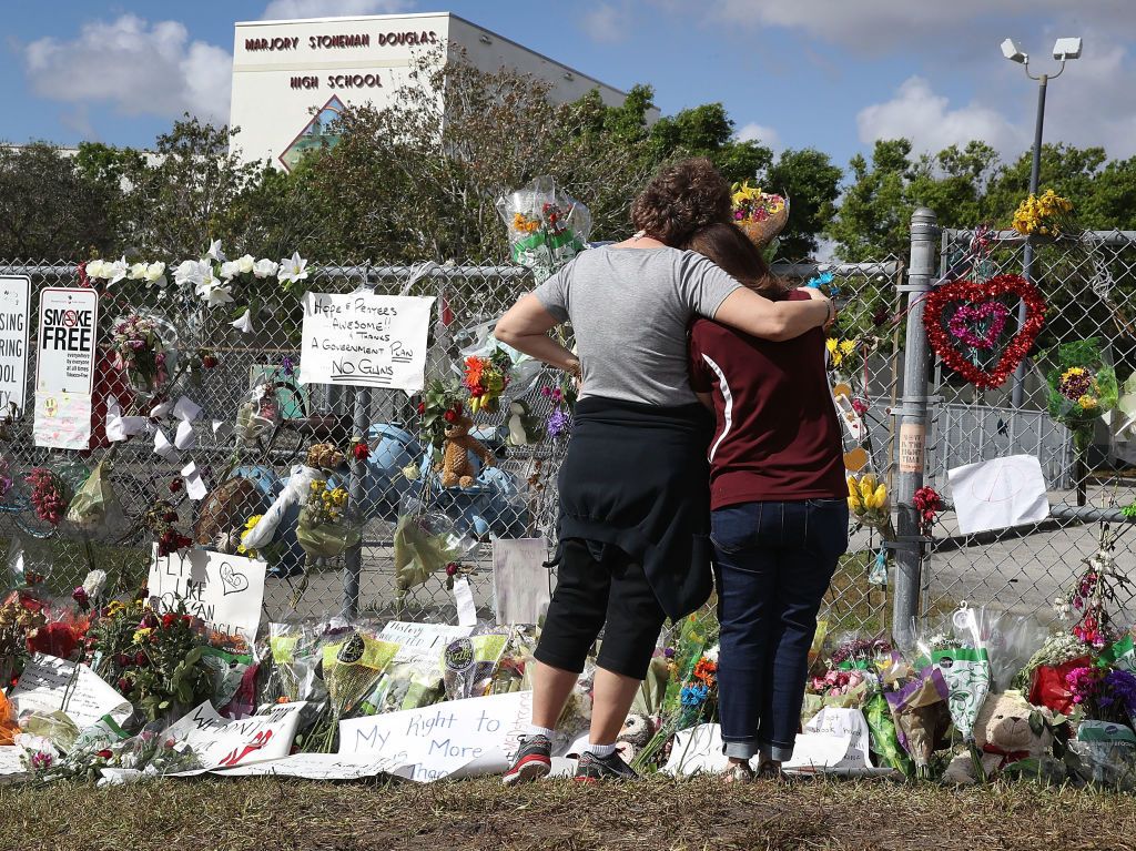 Teachers hug outside Marjory Stoneman Douglas High School.