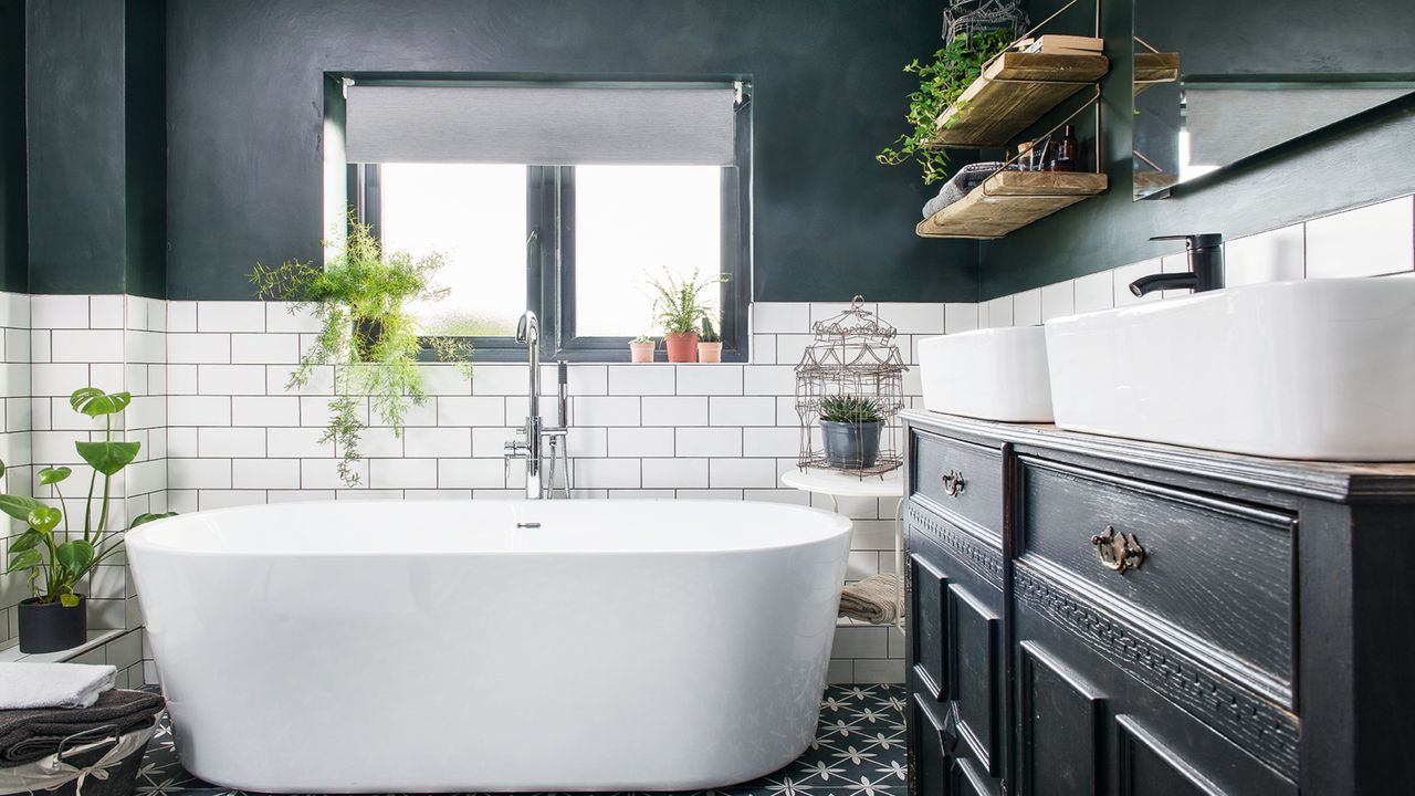 Modern bath in a dark grey and white tiled bathroom, an upcycled washstand and double basin and a black and white tiled floor