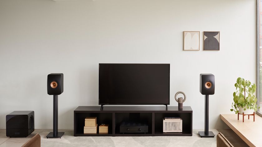 KEF LS50 Meta in black finish on matching stands in a living room with a TV