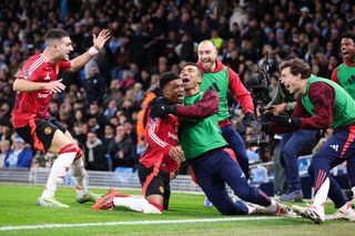 Amad Diallo of Manchester United celebrates with teammates after scoring their side's second goal during the Premier League match between Manchester City FC and Manchester United FC at Etihad Stadium on December 15, 2024 in Manchester, England.