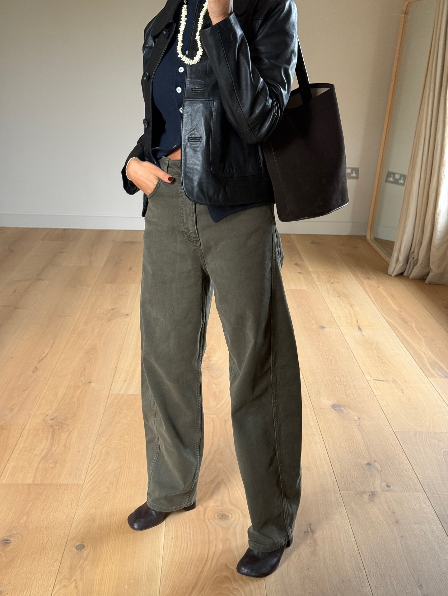 Marianne Smyth wears khaki jeans, a navy cardigan and a black leather jacket