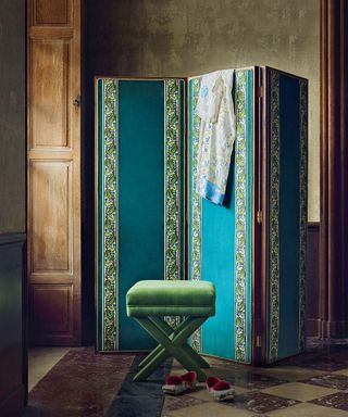 Blue screen with green trim, dark wood background, green velvet stool