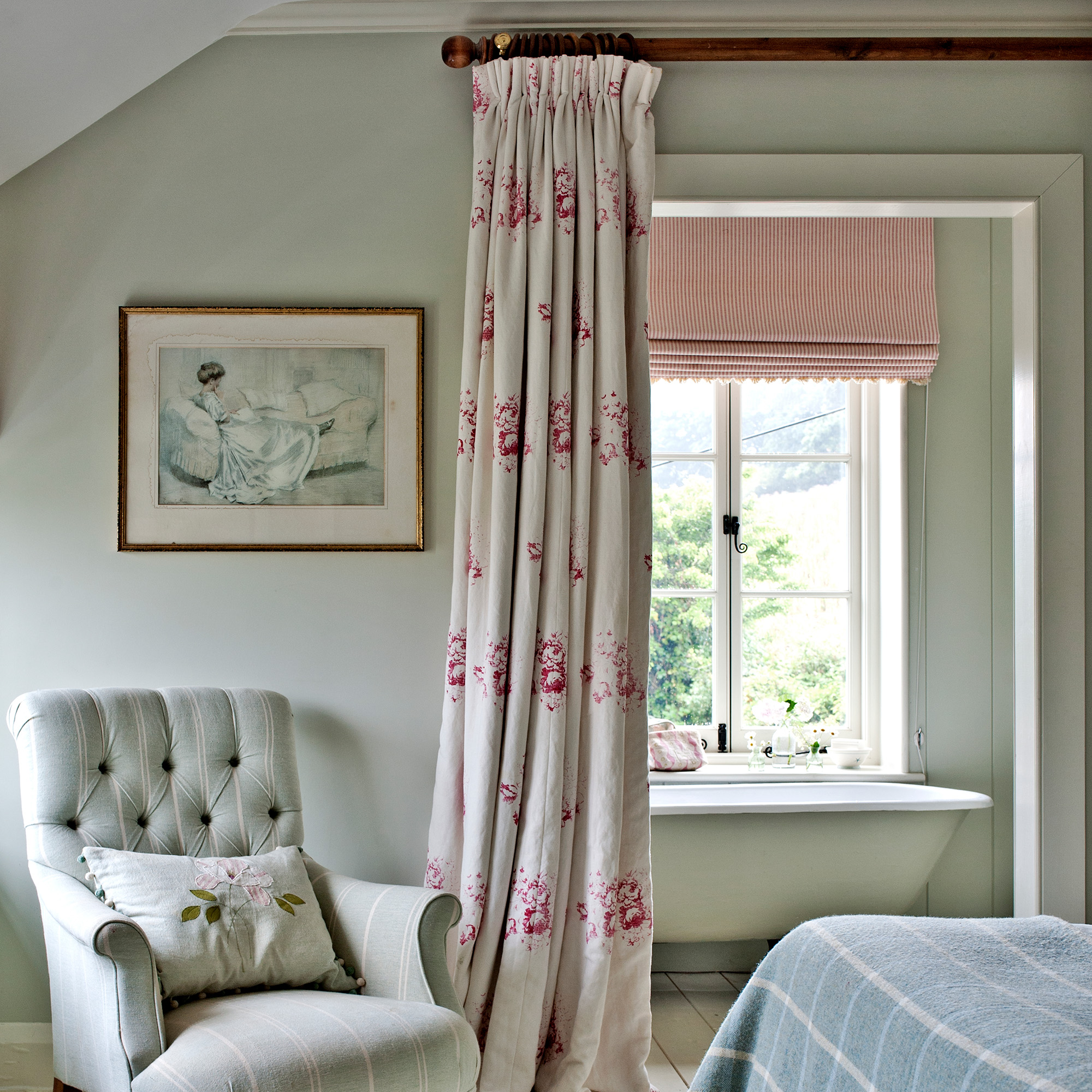 ensuite with pale green bath and pink blind with curtain door and blue striped bedlinen