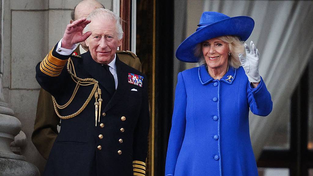 King Charles III and Britain's Queen Camilla wave to crowds, on the balcony of Buckingham Palace after attending the armed forces procession on May 5, 2025 to celebrate the 80th anniversary of VE Day