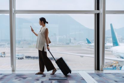 a woman glancing at her phone at the airport