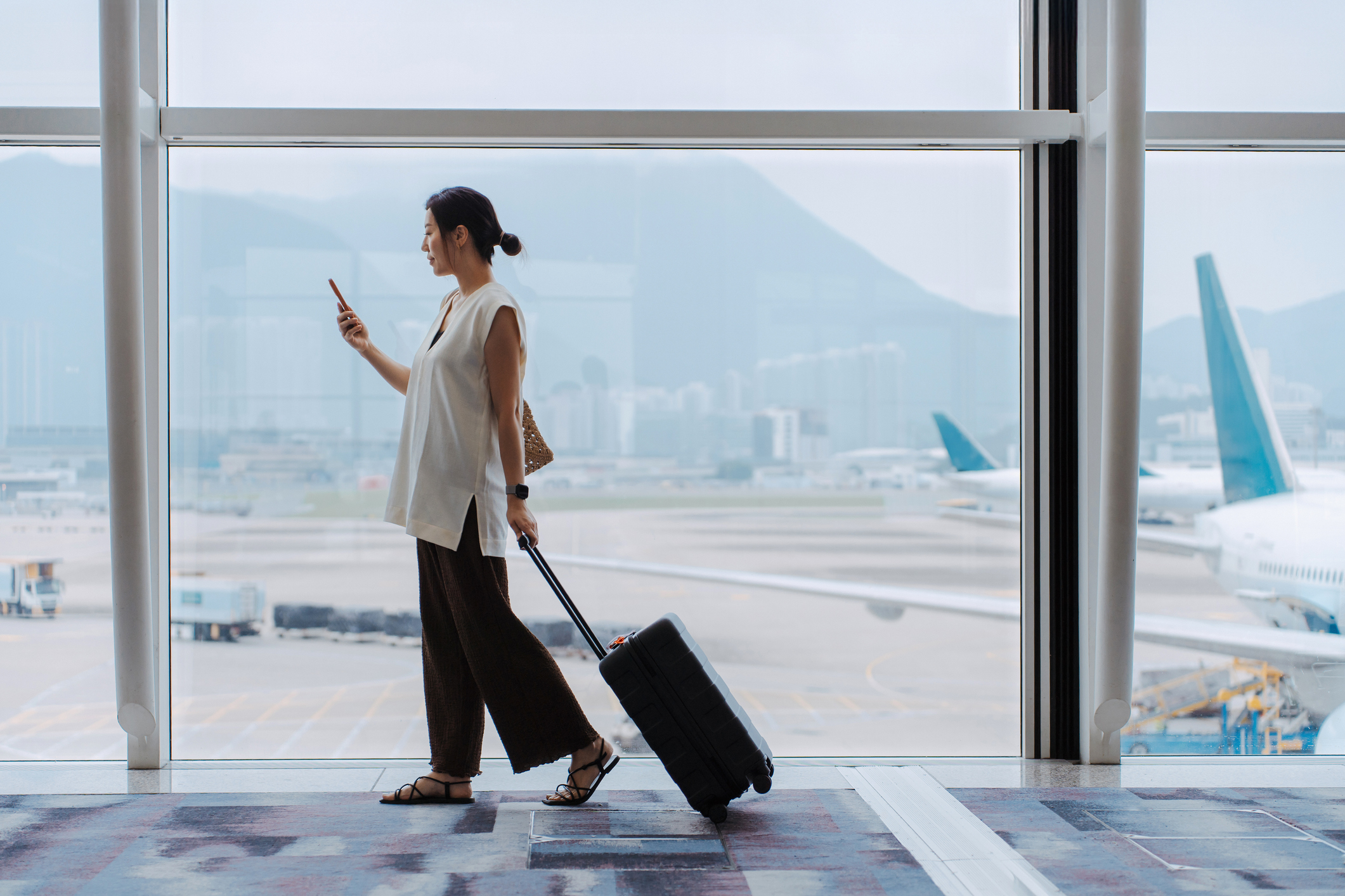 a woman glancing at her phone at the airport