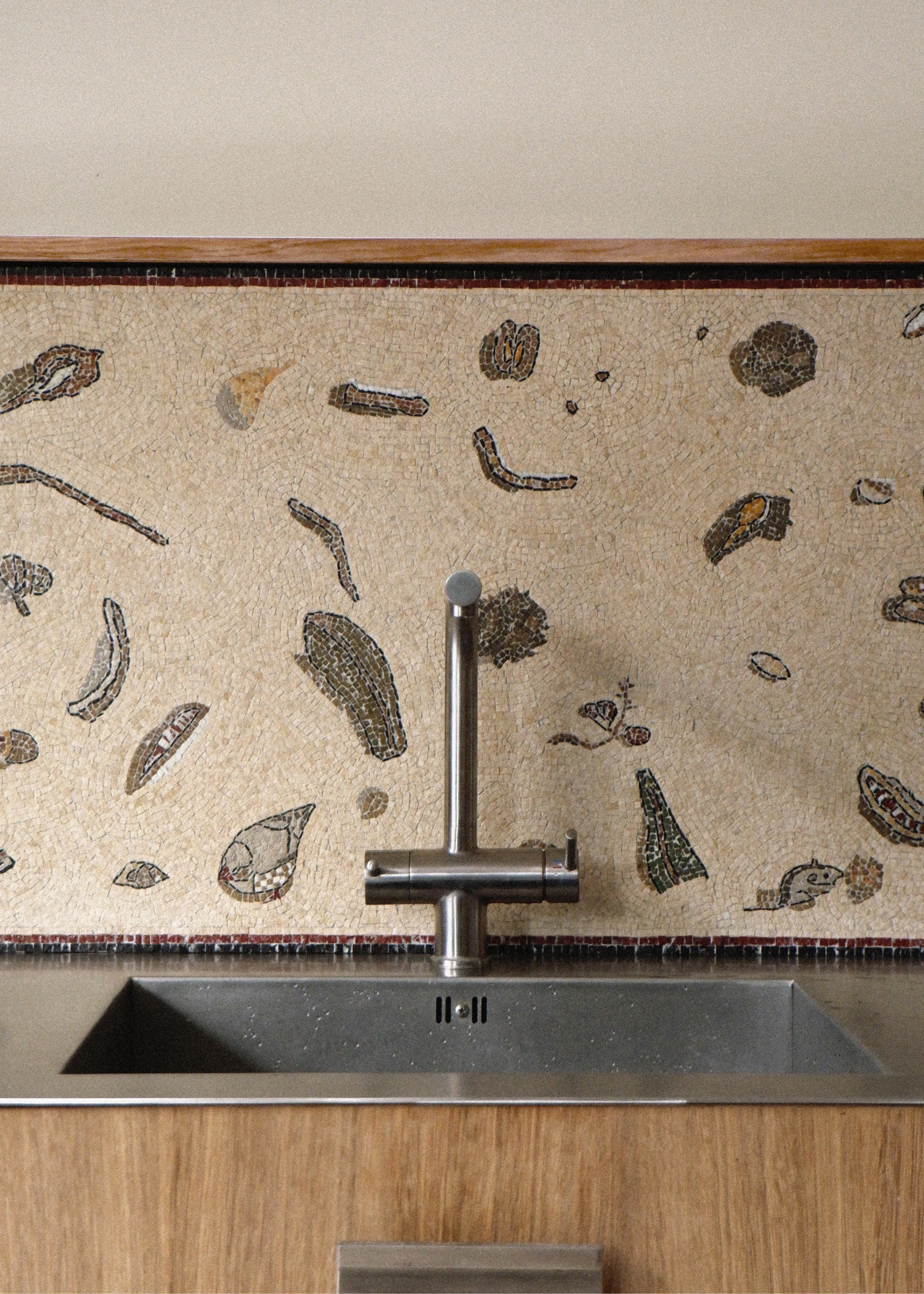 a mosaic tile splashback in a modern kitchen, done in the style of an unswept floor