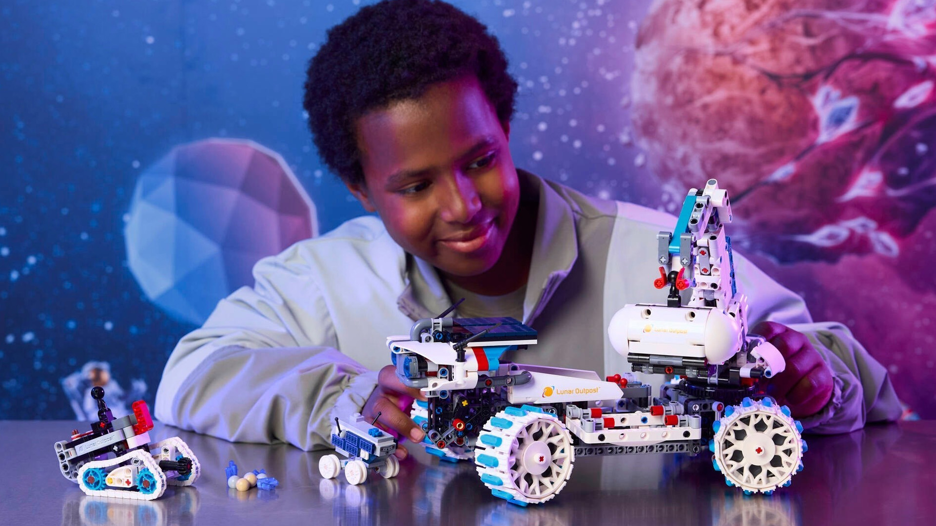 A boy playing with the Lego Technic Lunar Outpost Moon Rover Space Vehicle