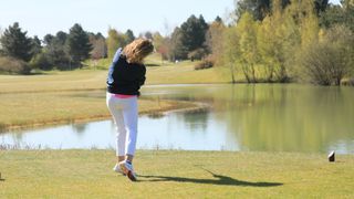 A female golfer hitting a tee shot at Essendon Golf Club
