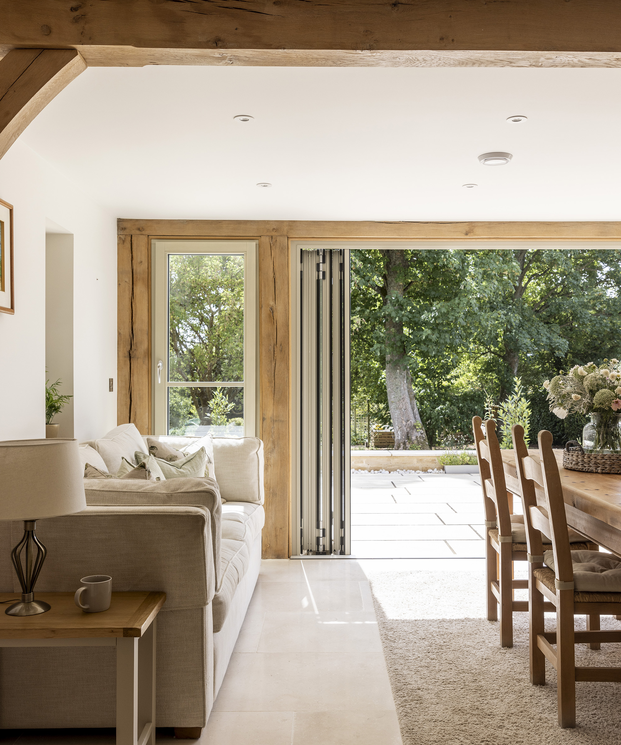 A large open plan dining room and living space with bifold doors opening out onto a patio