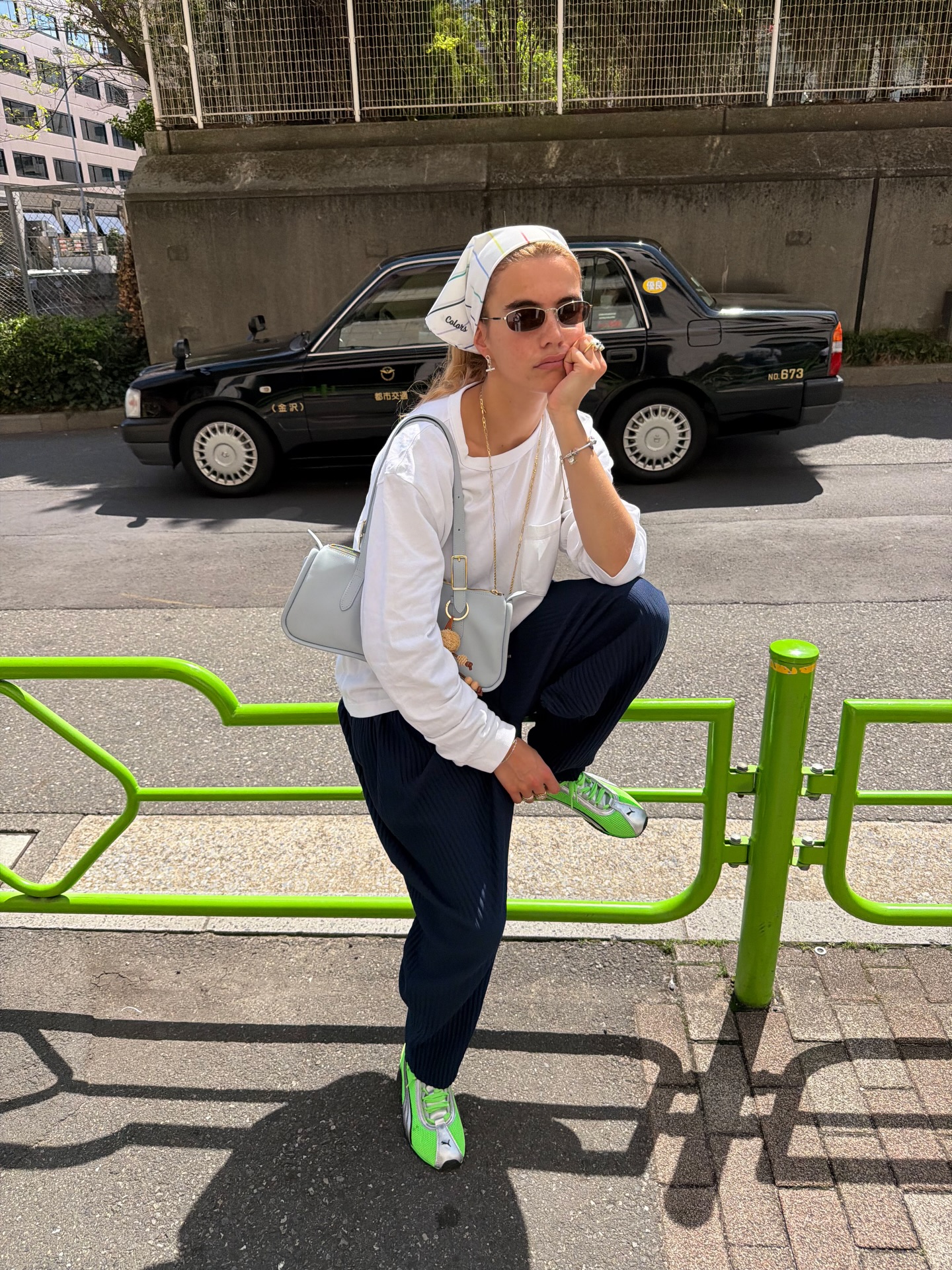 Influencer Tori Van Breugel wearing a head scarf, long sleeve t-shirt, barrel leg trousers and neon trainers.