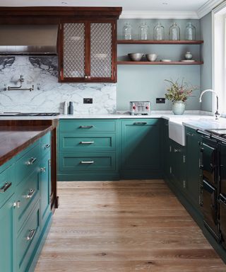 Kitchen layout ideas in a teal scheme with marble backsplash and open shelving.