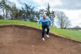 Using club to prevent a fall in a bunker