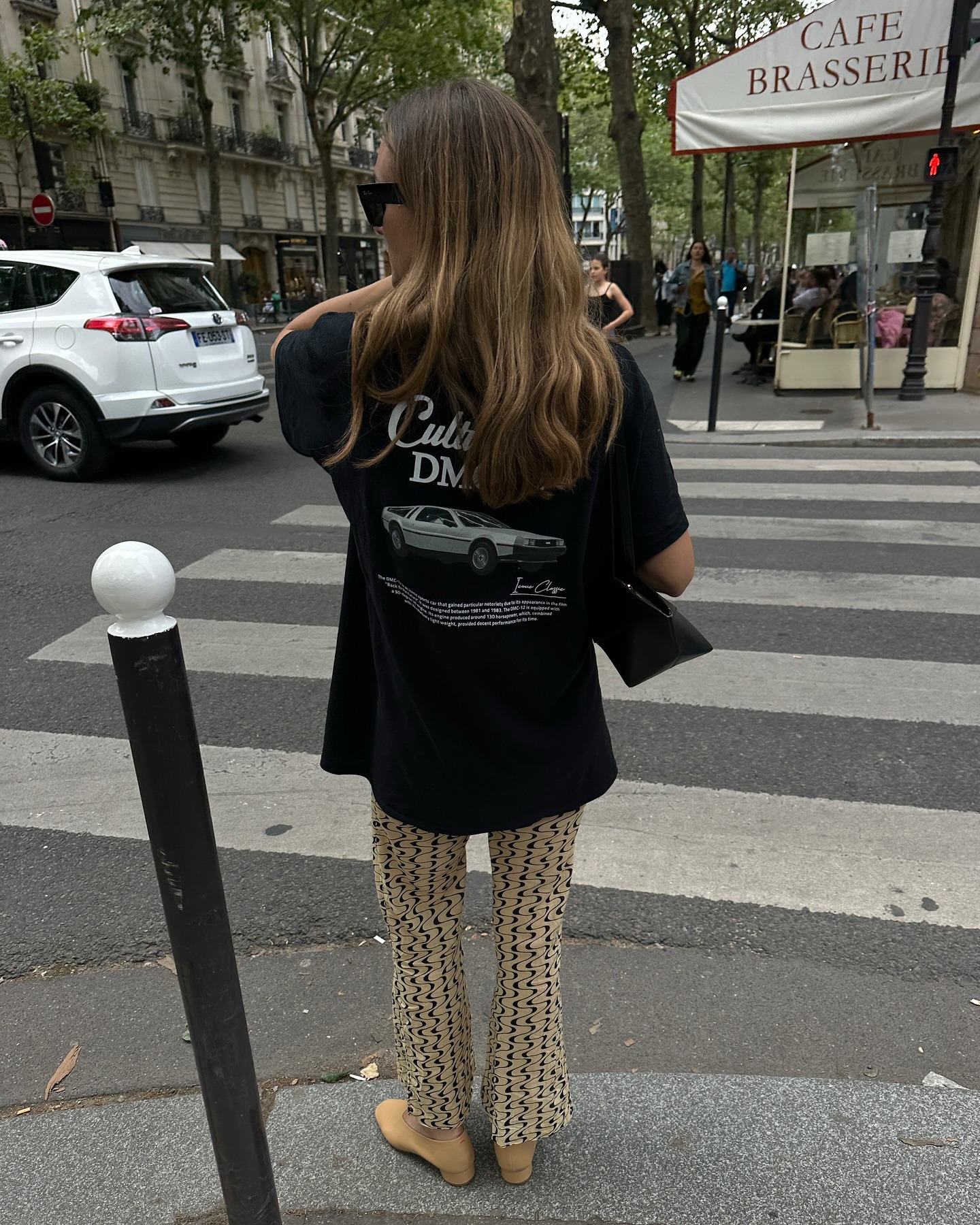 @annelauremais wearing a black oversized graphic T-shirt with patterned pants.