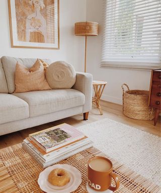 A beige and white living room with a couch, coffee table, and a lamp