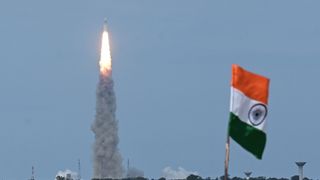 a rocket launches in the background behind an indian flag