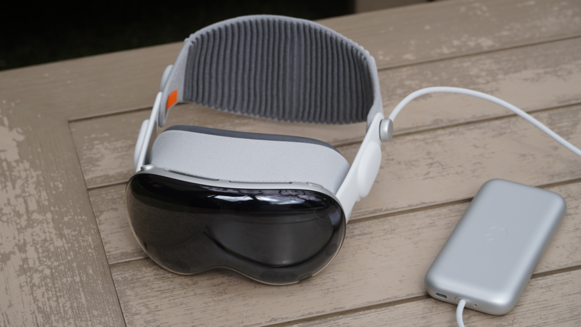 Apple Vision Pro on table with outdoor accessories.