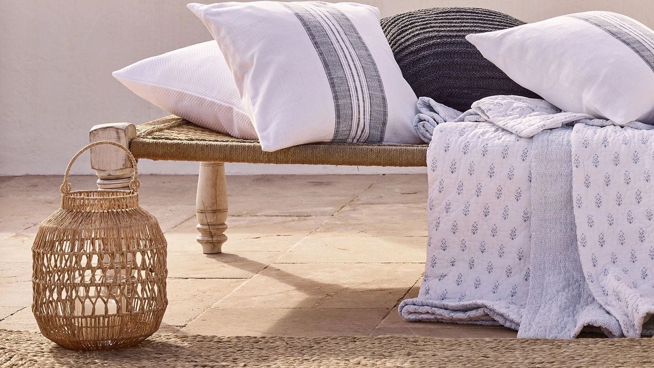 The White Company jute candle holder outside next to seating