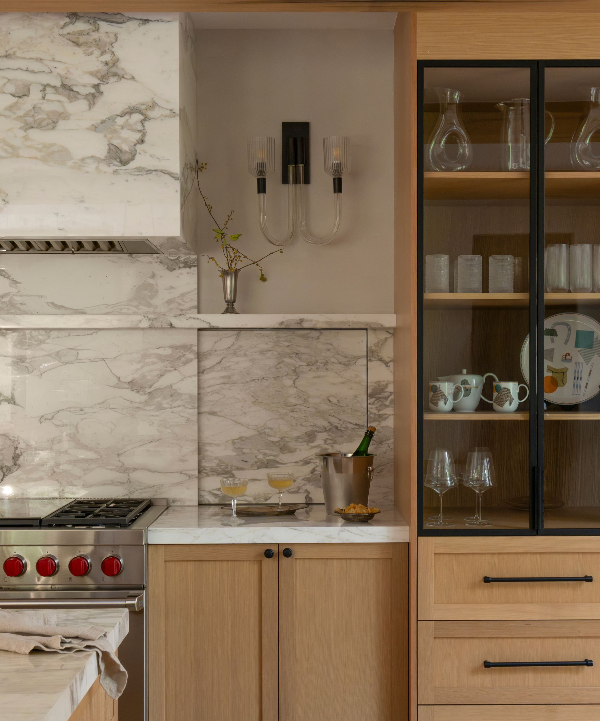 A wooden kitchen with hidden storage behind the marble backsplash