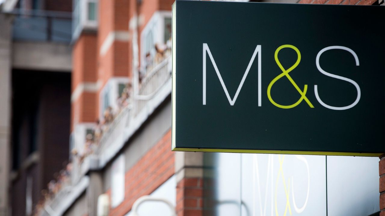 A Marks &amp; Spencer logo sits on a sign outside a retail store, operated by Marks &amp; Spencer Group Plc (M&amp;S) in London, U.K., on Monday, April 7, 2014. Almost two years after cutting his projection of long-term sales growth at Marks &amp; Spencer Group, Chief Executive Officer Marc Bolland will unveil figures this week indicating even that was too optimistic.