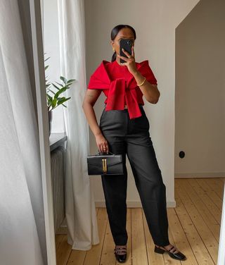 @femmeblk wearing a red t-shirt with jumper tied across and tailored trousers