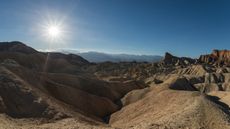 The dramatic badlands of Zabriskie Point in Death Valley lit by the late afternoon sun.