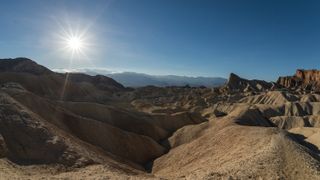 The dramatic badlands of Zabriskie Point in Death Valley lit by the late afternoon sun.