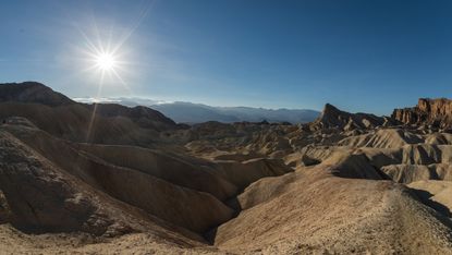 The dramatic badlands of Zabriskie Point in Death Valley lit by the late afternoon sun.