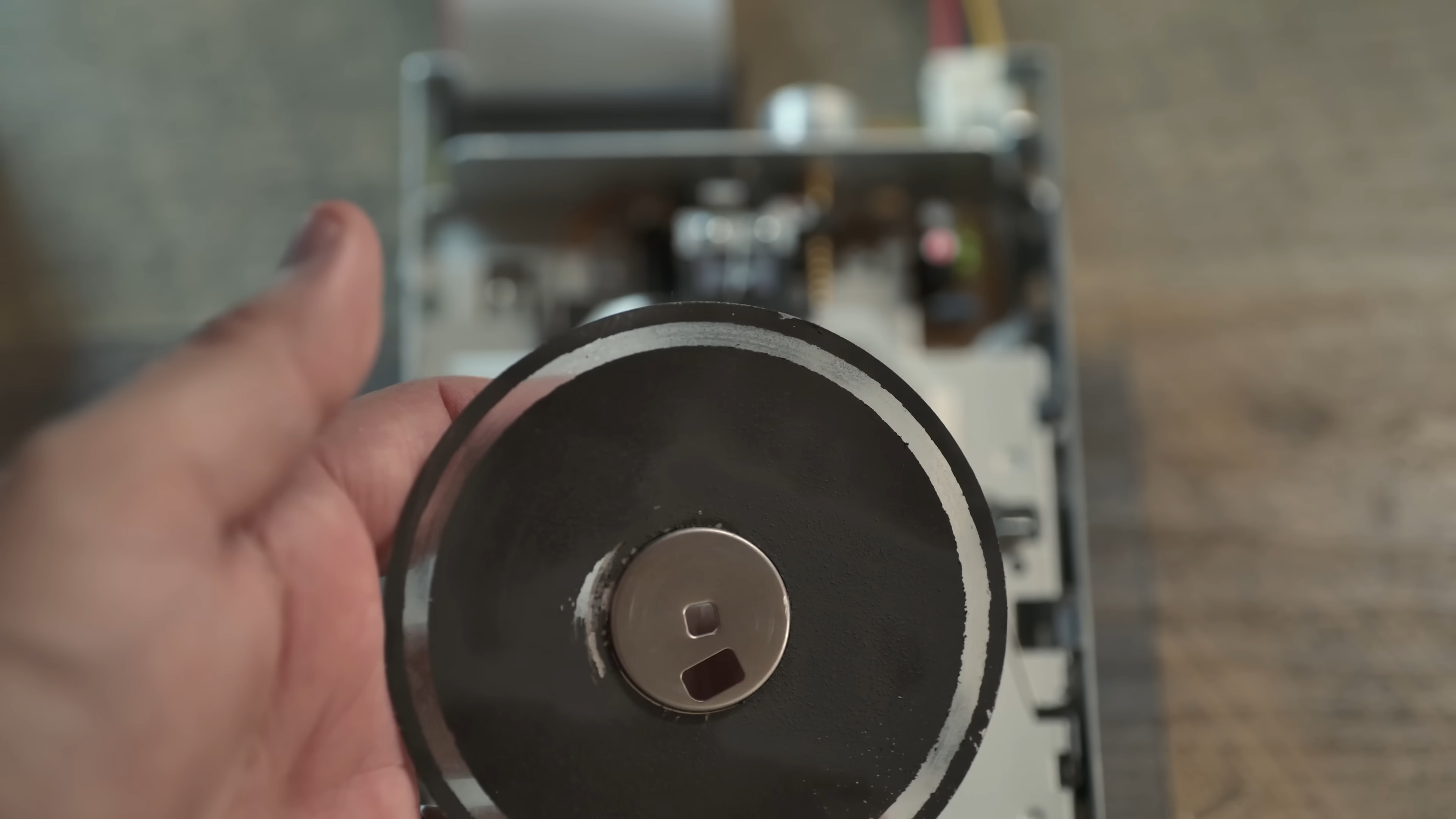 A damaged homemade floppy disk coating, held in the hand