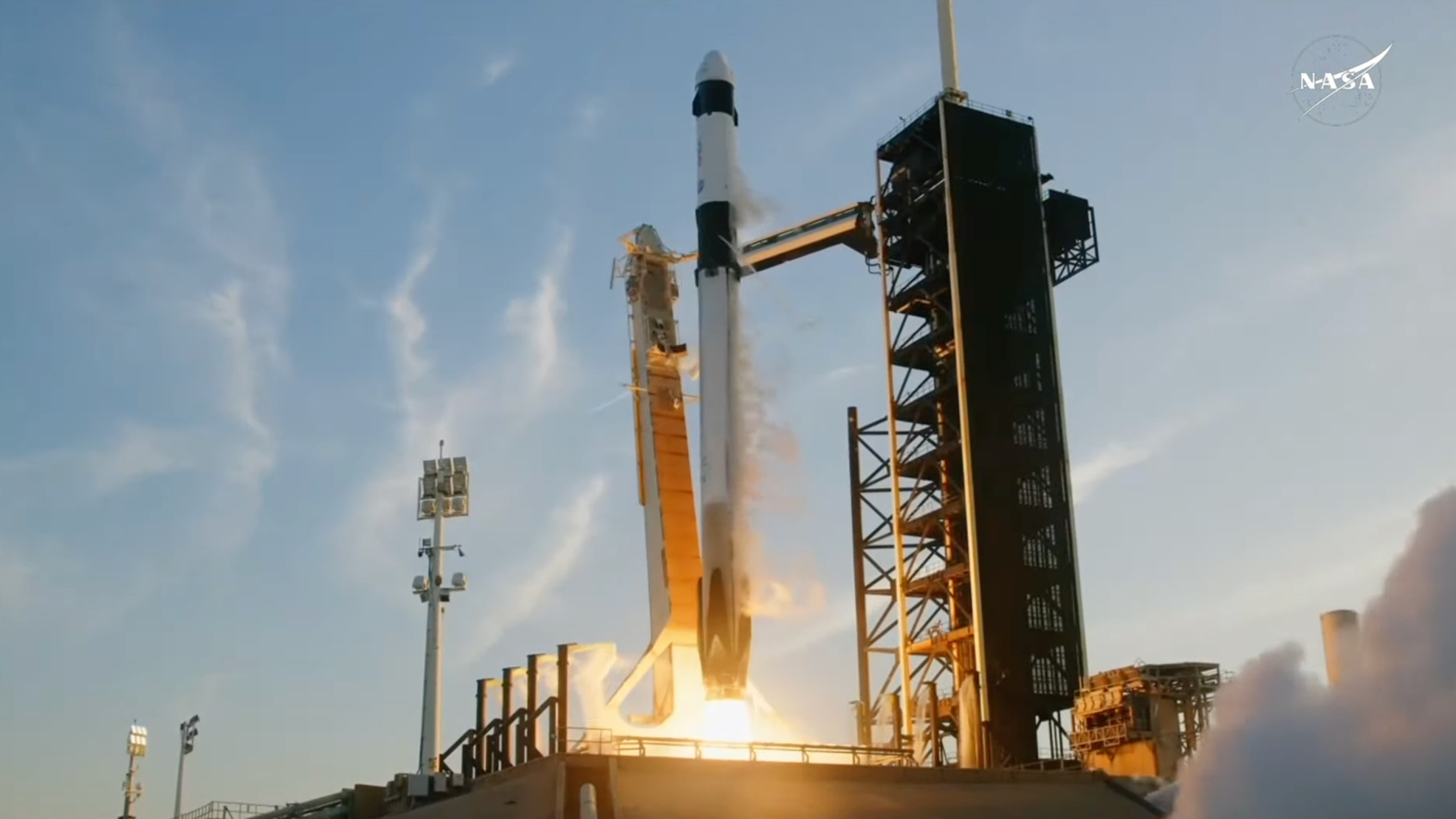 a black and white rocket launches into a blue sky